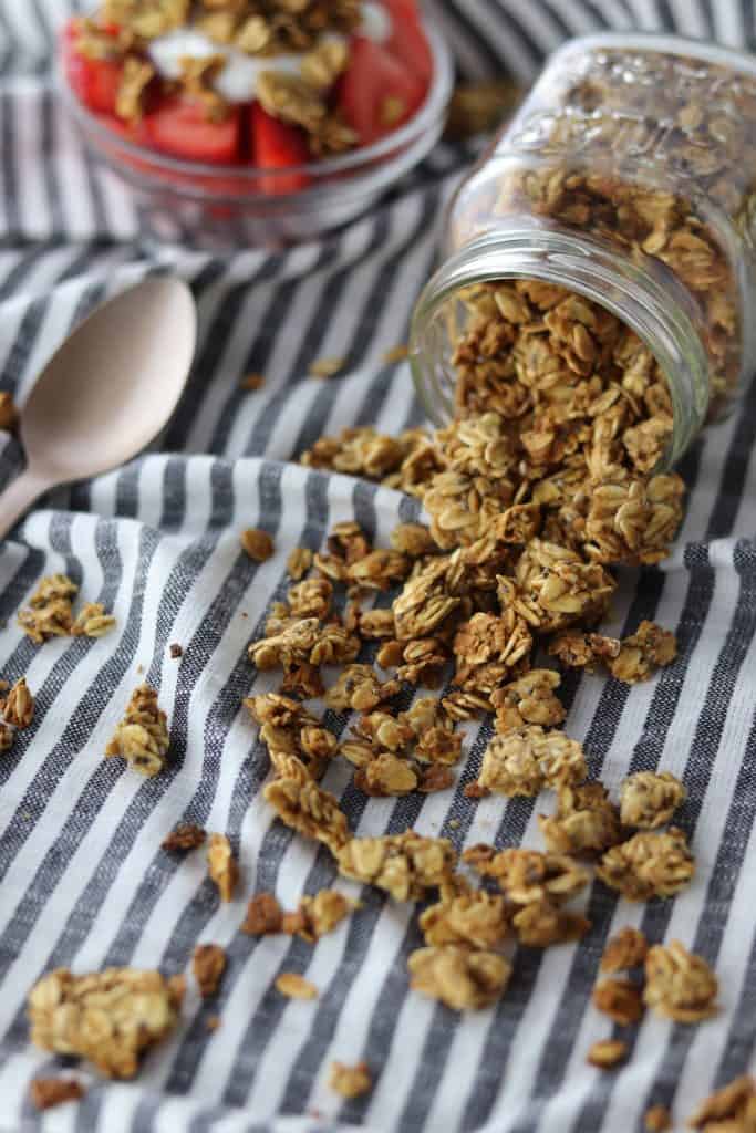 chia & flax granola pouring from jar with parfait