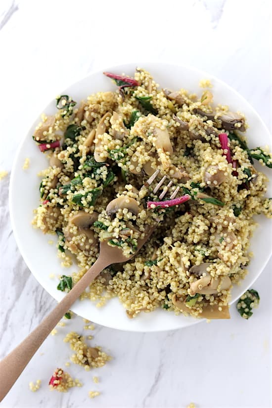 swiss chard and mushroom quinoa on marble counter