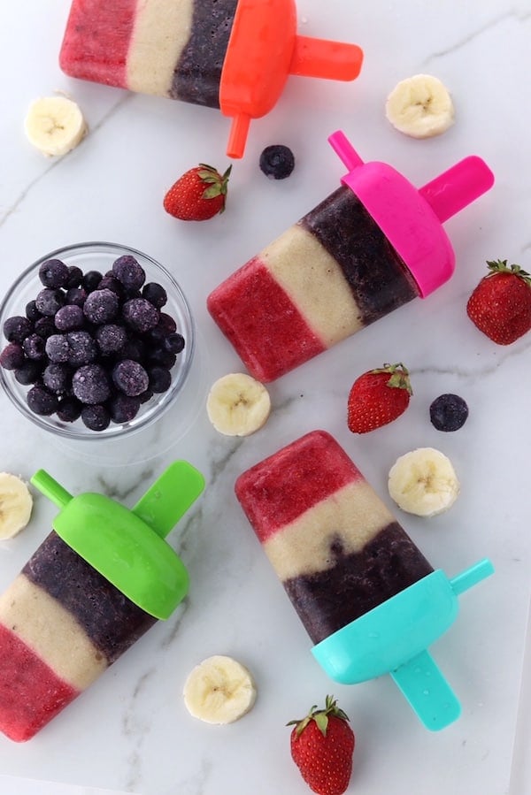 red white and blue fruit pops with blueberries banana and strawberries on counter