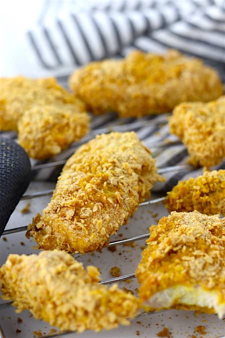 Baked turmeric chicken tenders on a cooling rack close up