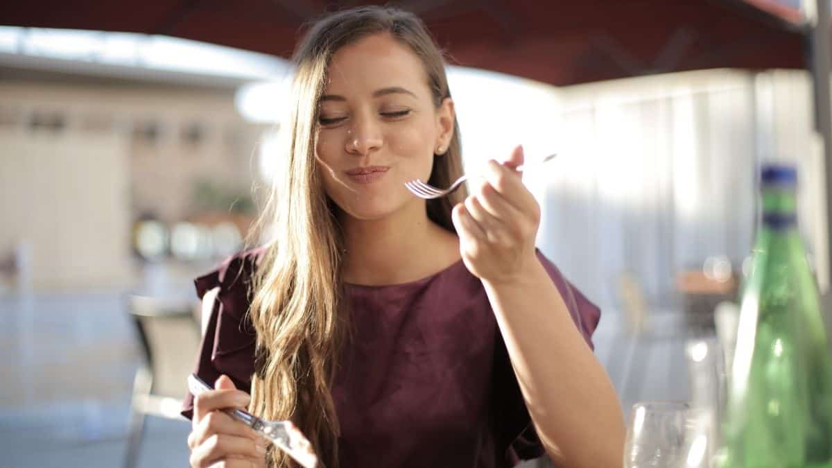 Woman Eating From A Fork Smiling.