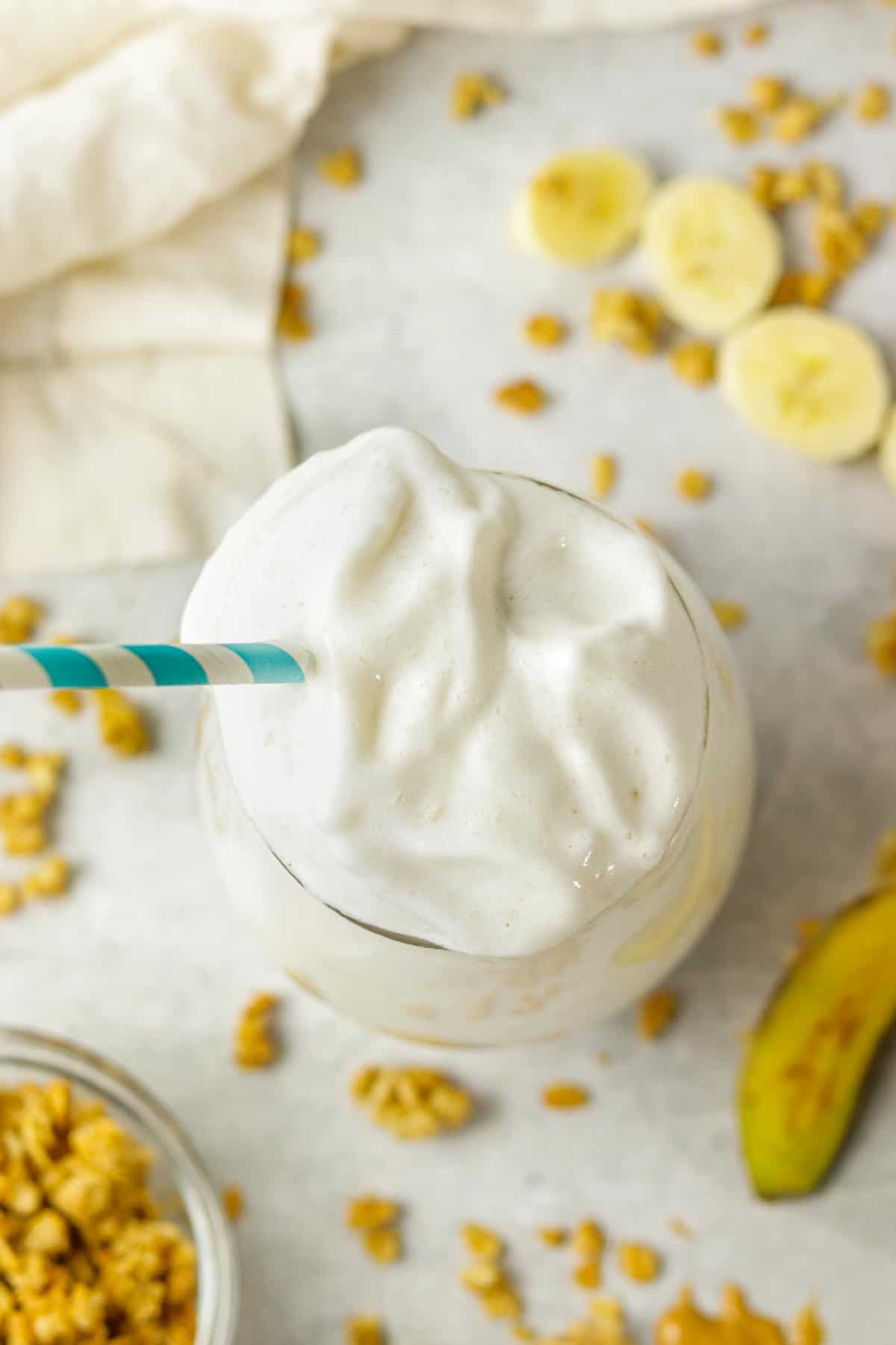top of a banana protein shake with granola around the sides.