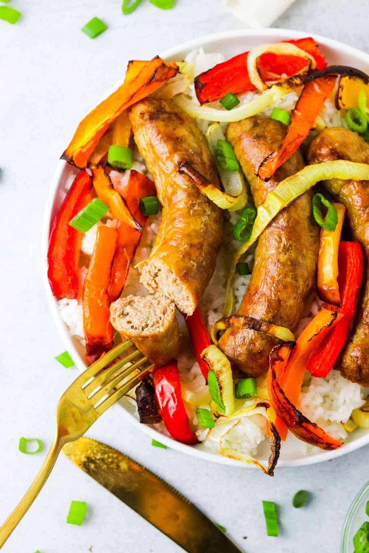 cut sausage on a plate with peppers and rice