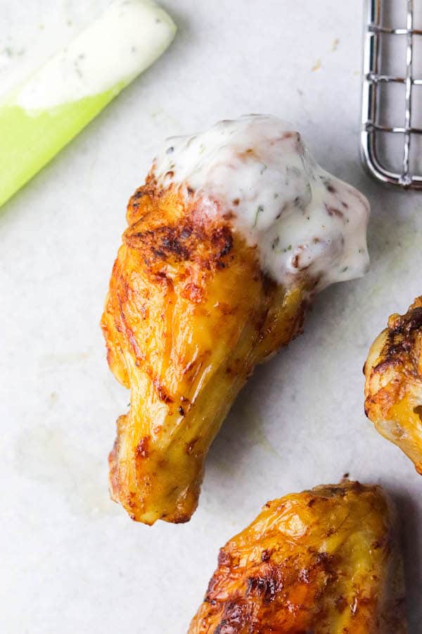 A chicken wing, dipped in a creamy sauce