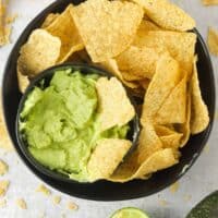 A bowl of avocado lime crema with tortillas chips.
