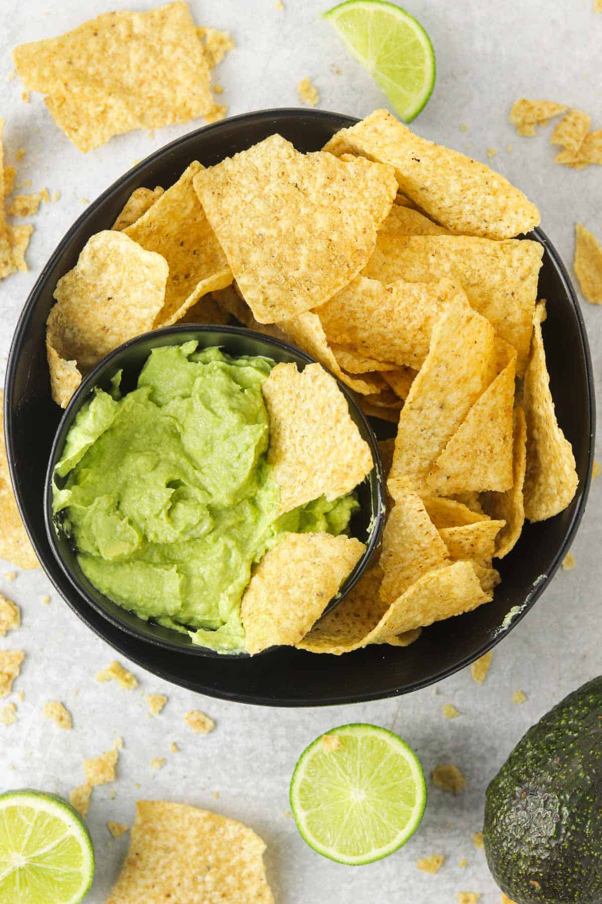 A bowl of avocado lime crema with tortillas chips.