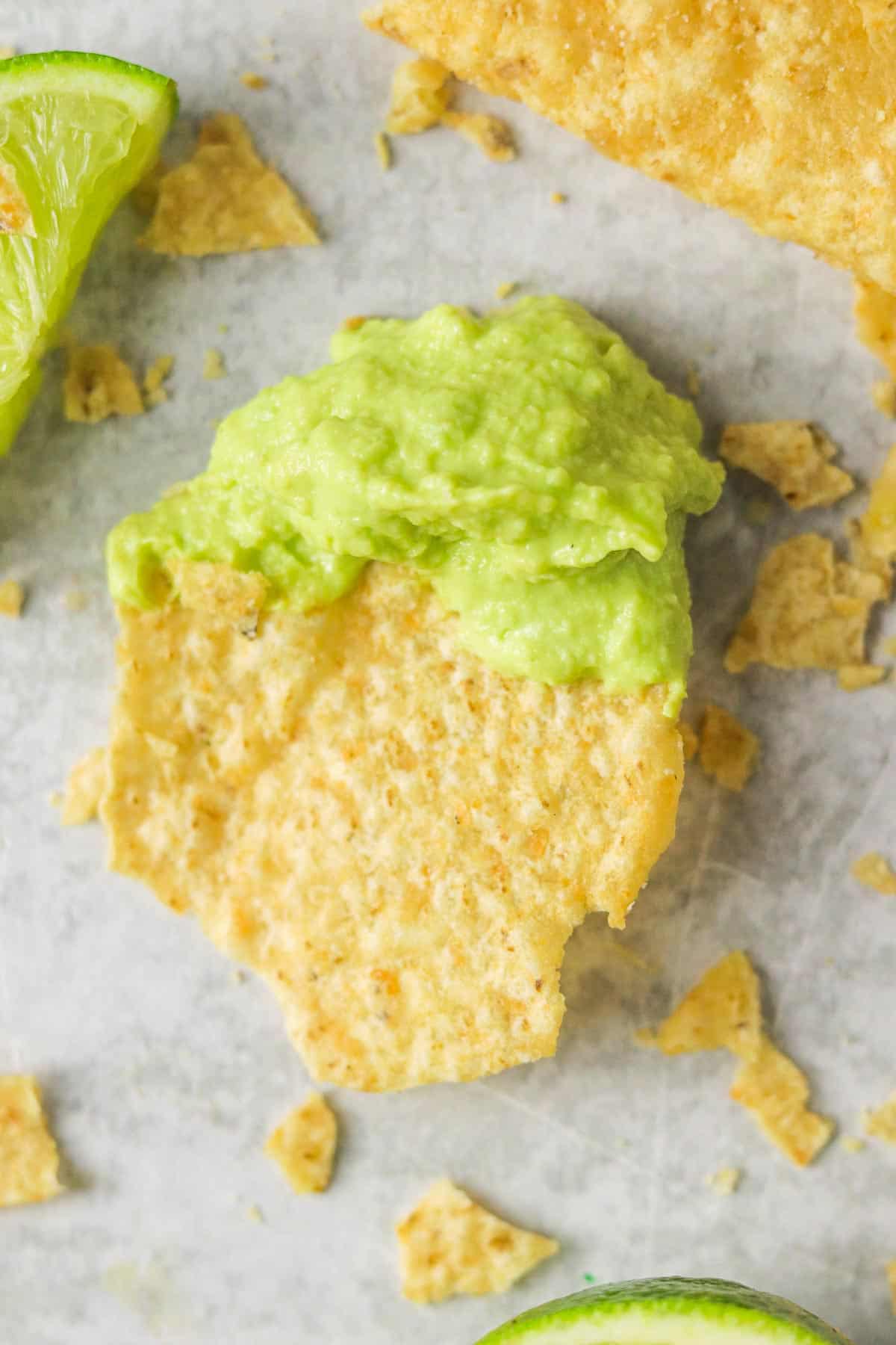 A tortilla chip dipped into avocado lime crema.