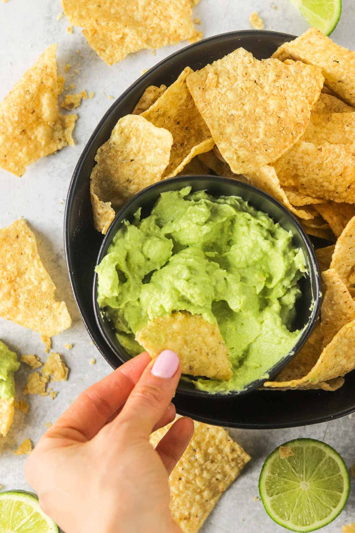 Dipping a chip into a bowl of avocado lime crema