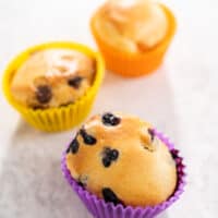 fruit, veggie and chocolate air fryer muffins sitting on the counter in colorful molds.