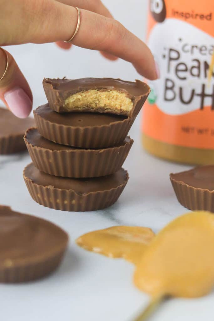 hand grabbing a homemade prefect bar peanut butter cups that are stacked