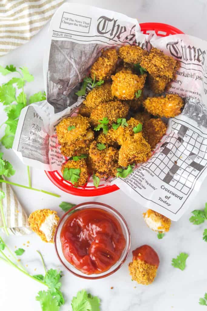 extra crispy spicy chicken nuggets in a basket with ketchup