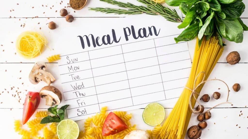 Blank meal planning calendar surrounded by healthy foods. 