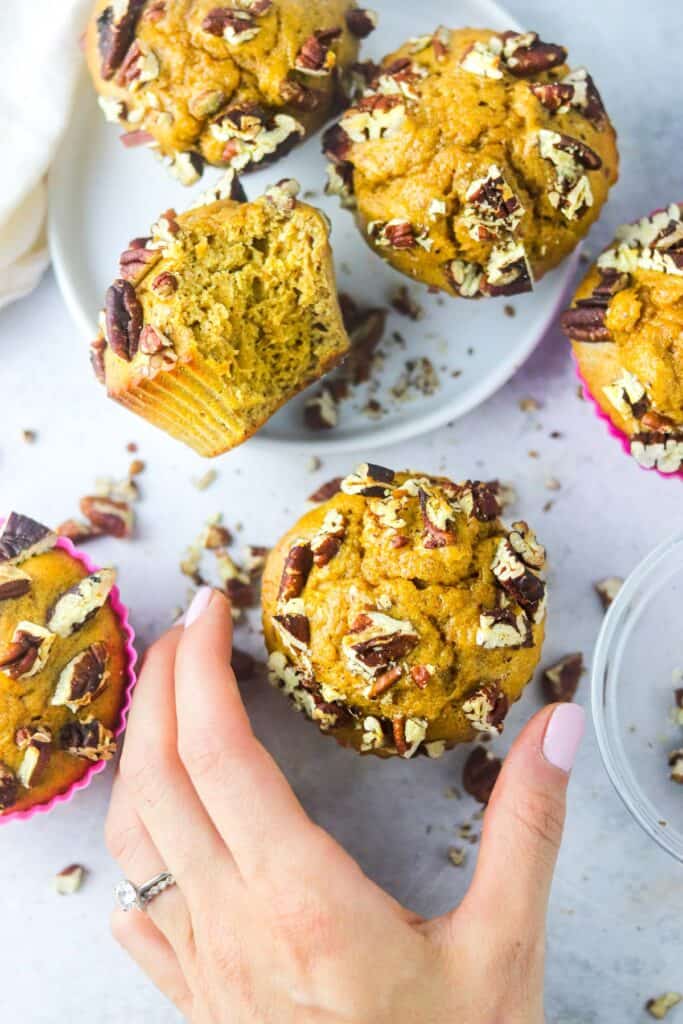 hand grabbing a pumpkin protein muffin