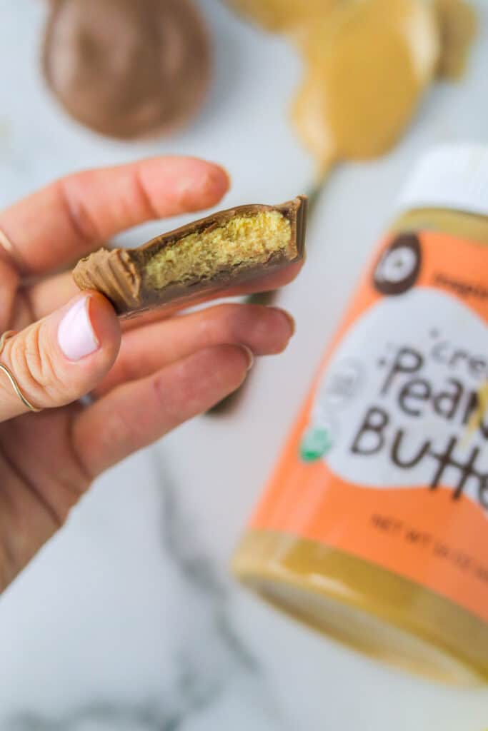 holding a he Perfect Bar cups have mostly the same ingredients, but also have either milk or dark chocolate as the #1 ingredient behind the nut butter