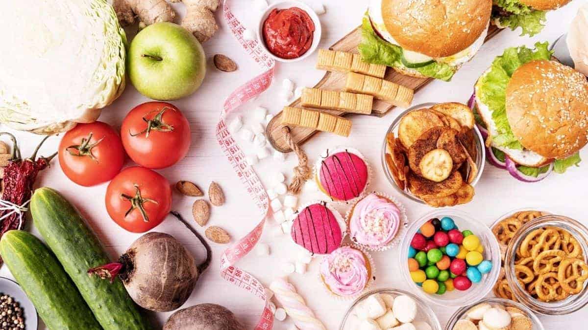 healthy and unhealthy foods together on a pink background.