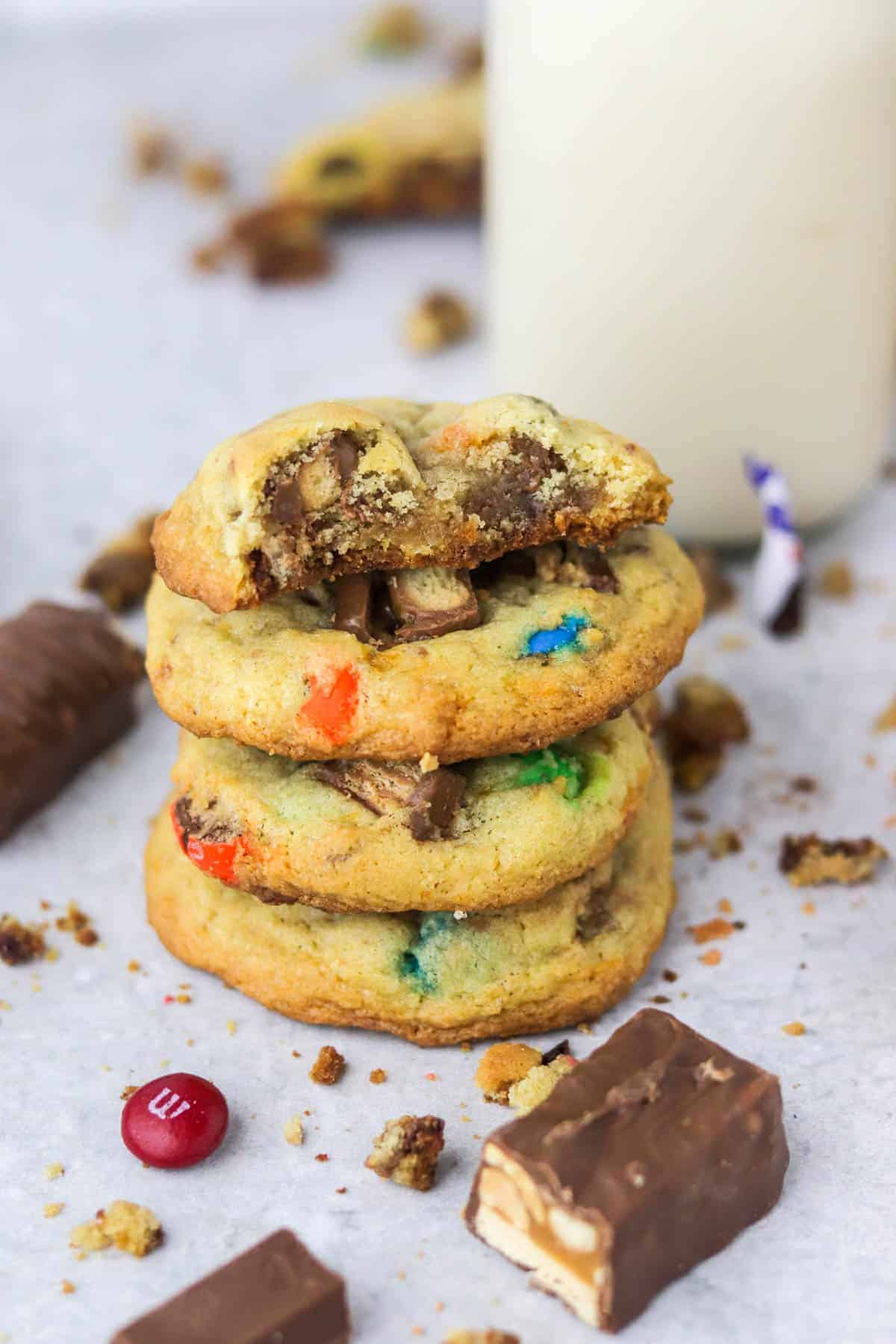 close up of stacked candy cookies with the top cookie half eaten.