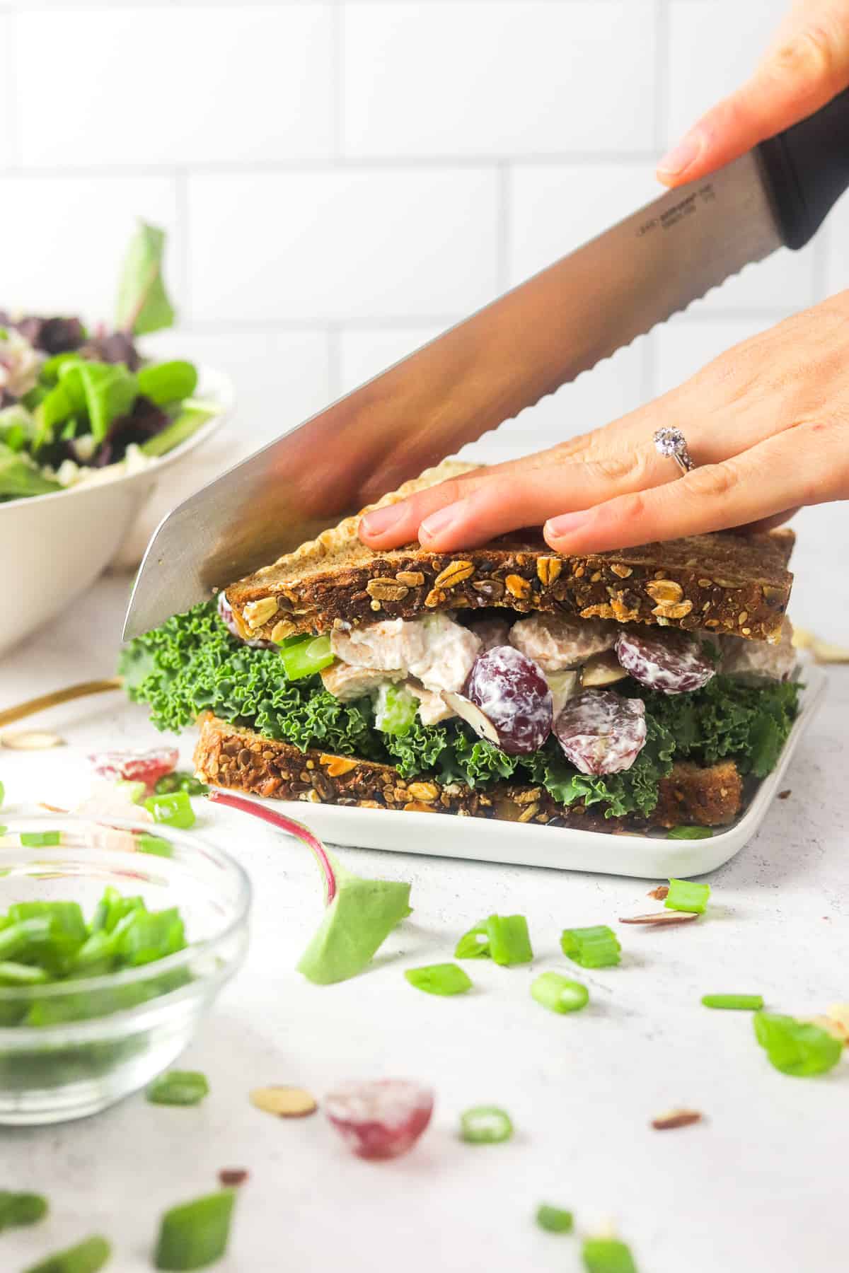 cutting turkey salad with grapes sandwich.