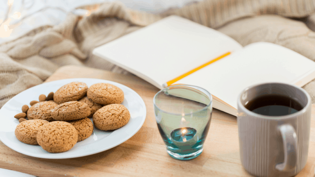 A cup of coffee on a table, with Tea and Cookies.