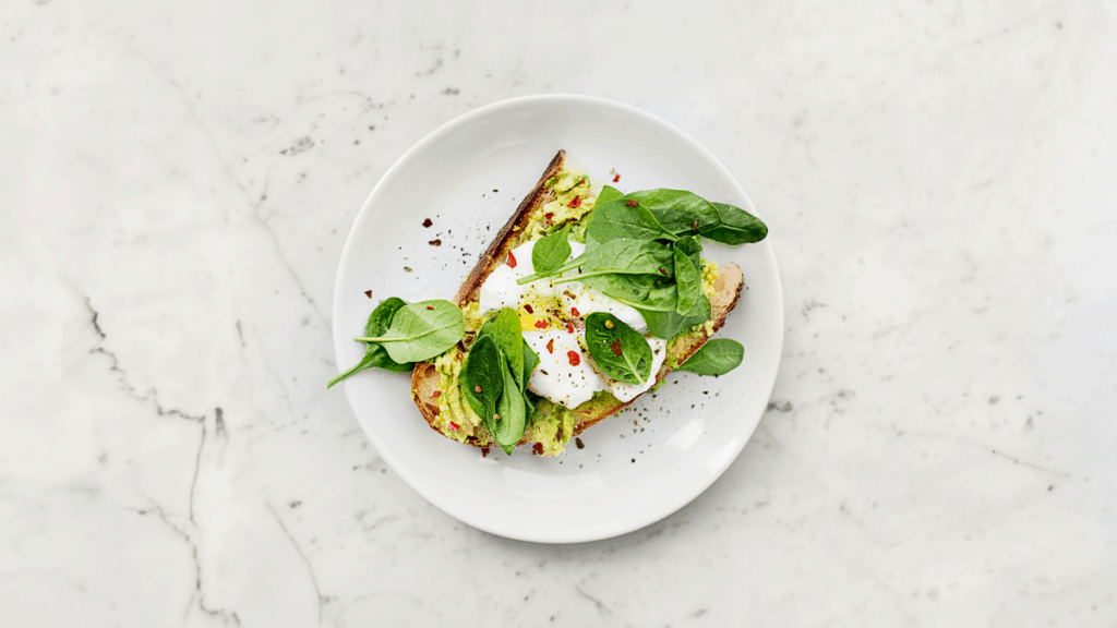 A white plate with toast and greens.