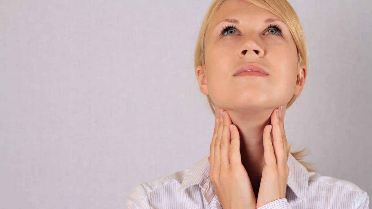 A woman holding her neck and looking up symbolizing hormone imbalance.