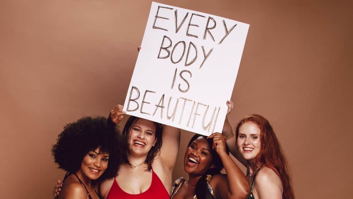 Women holding the sign saying every body is beautiful.