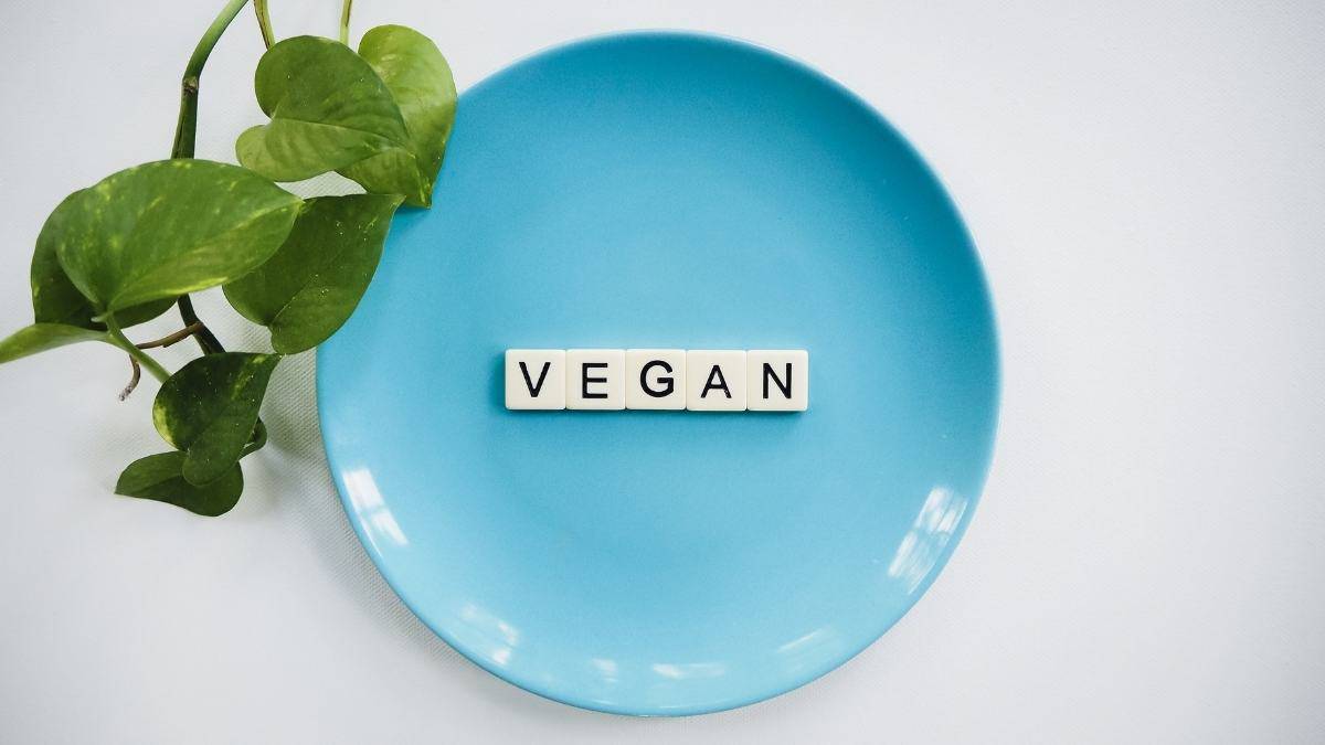 Vegan spelled in scrabble tiles on a blue plate.