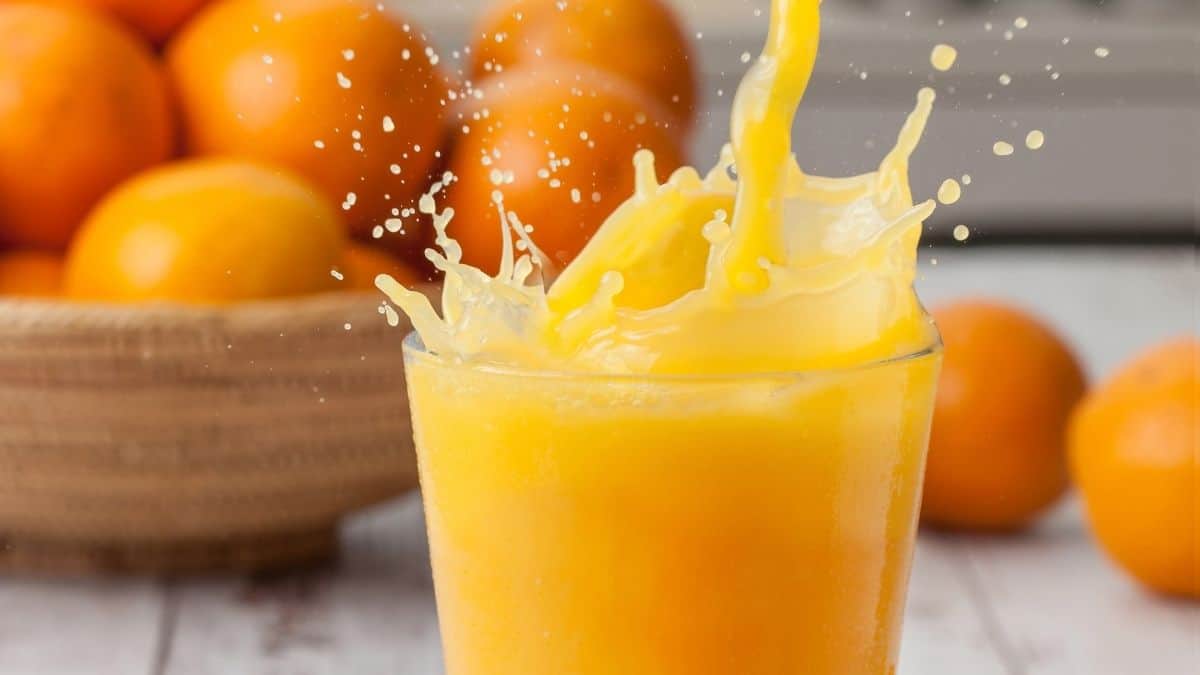 Glass of orange juice splashing.