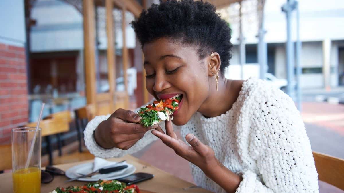 A woman sitting at a table eating pizza.