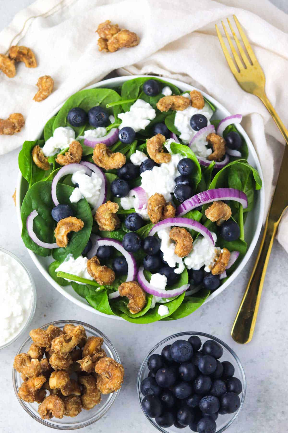 spinach blueberry salad with candied cashews on the counter.