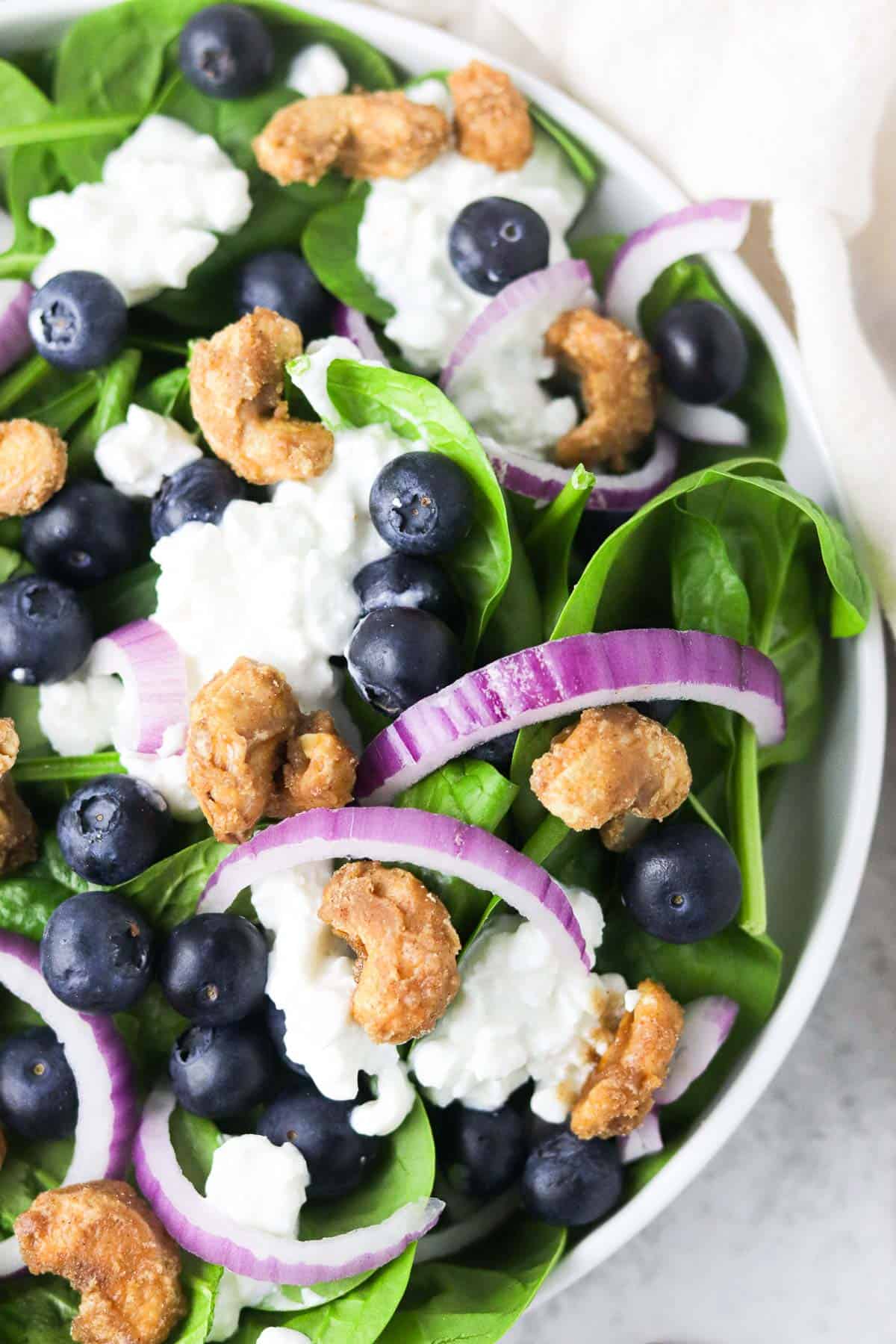 up close spinach blueberry salad with candied cashews.