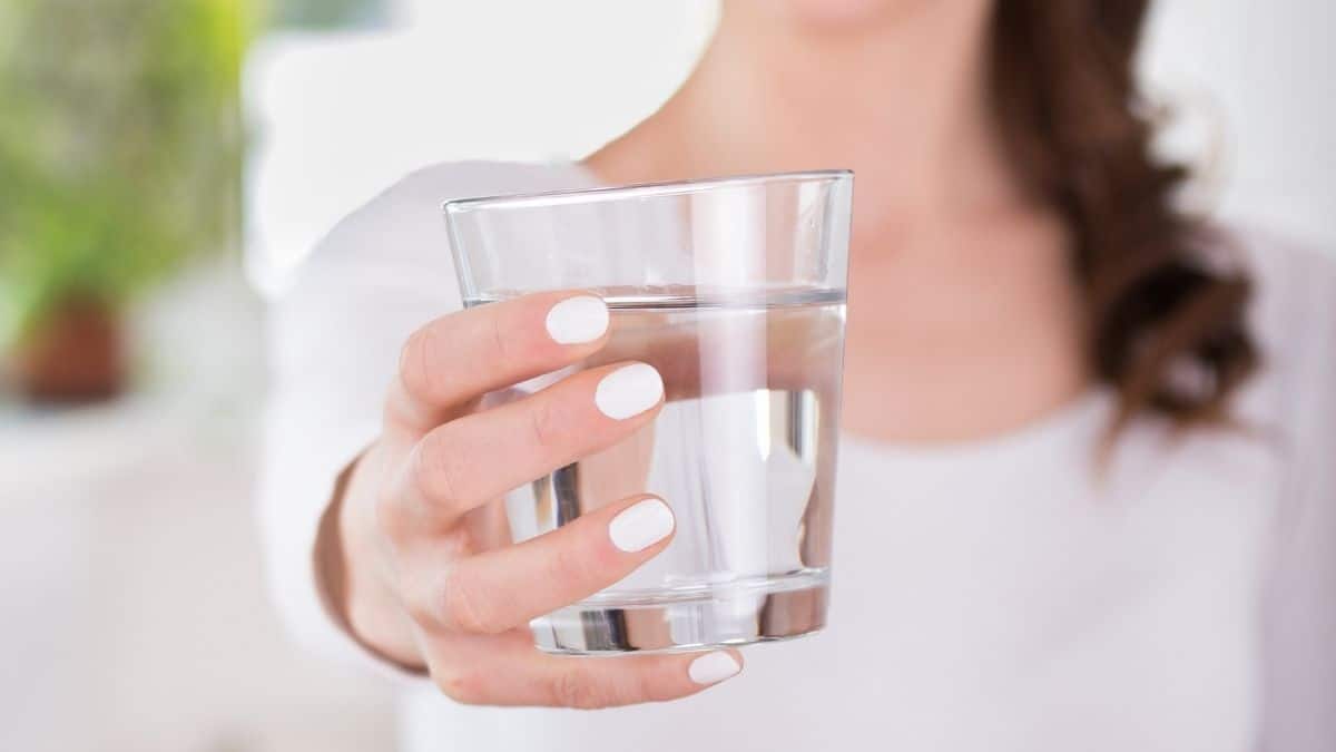 woman holding a glass of water.