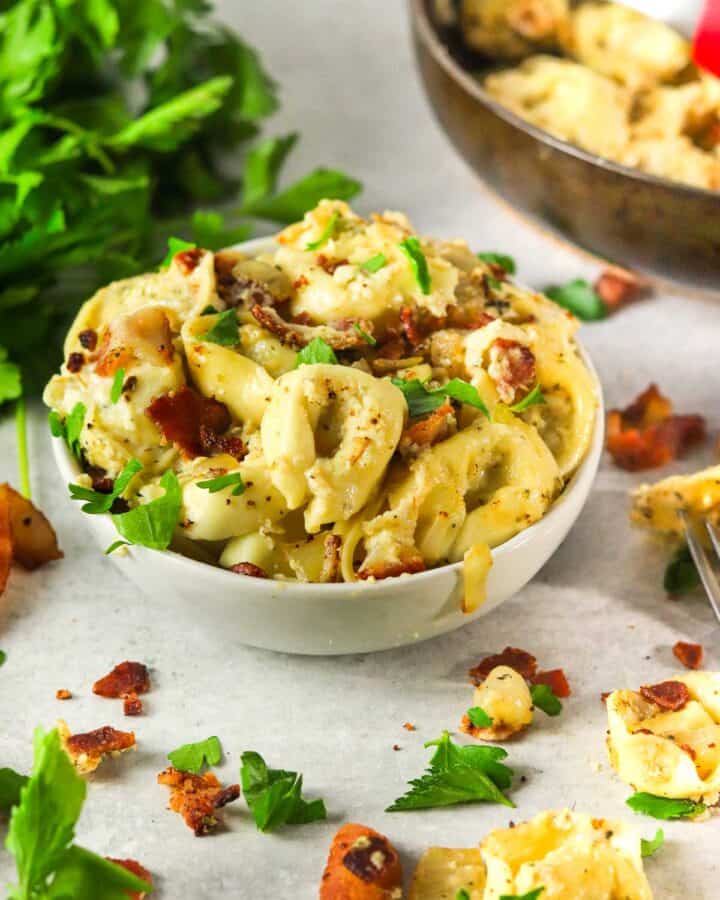 Side angle shot of tortellini carbonara pasta.