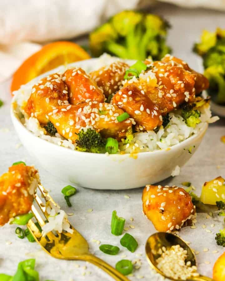 bowl of air fryer orange chicken with a piece on a fork..