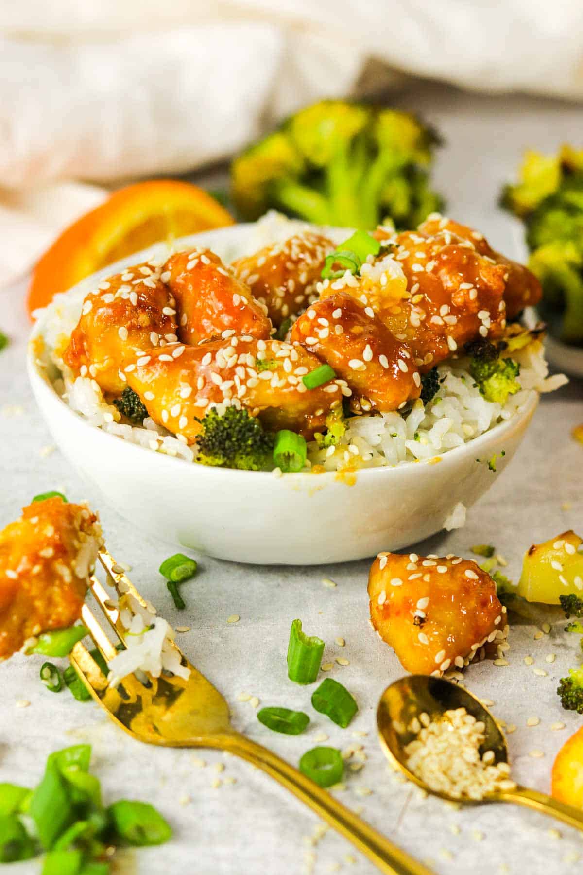 bowl of air fryer orange chicken with a piece on a fork..
