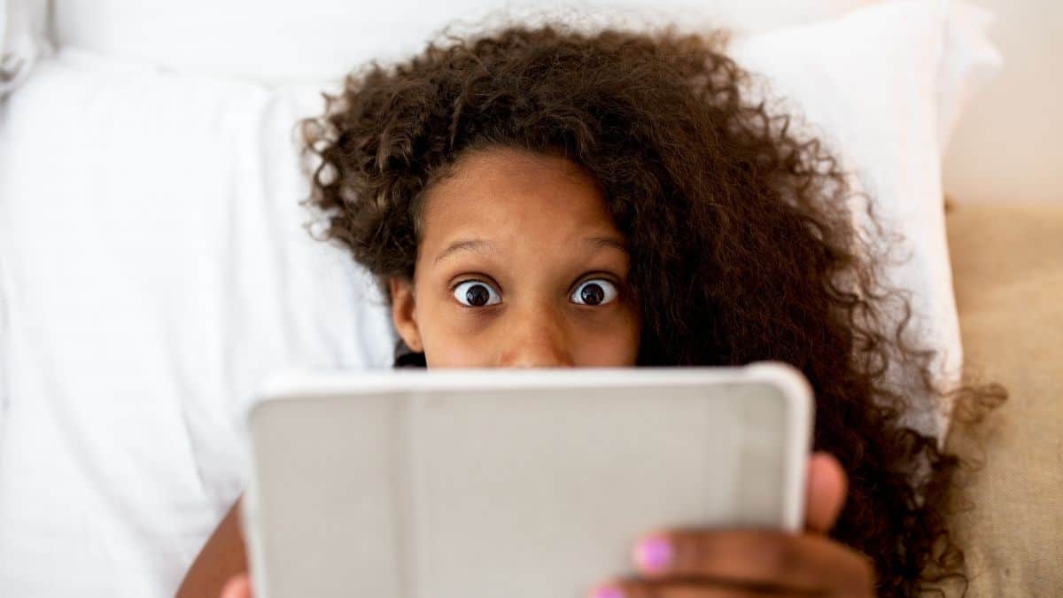 woman with a shocked expression while looking at ipad.