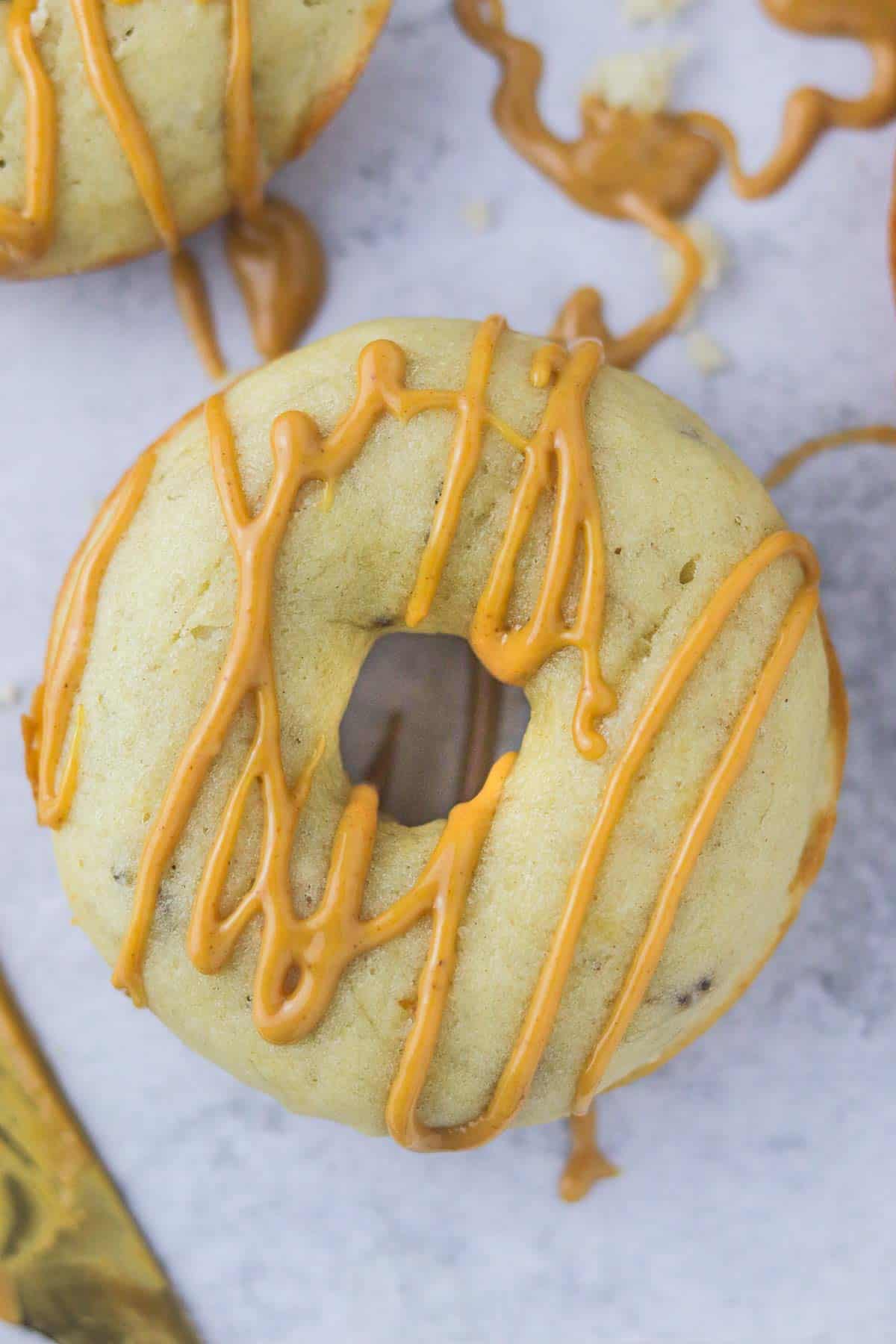 Close up baked banana donut drizzled with peanut butter