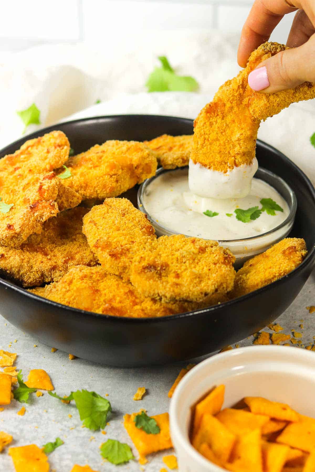 dipping Cheez It chicken Tenders into ranch