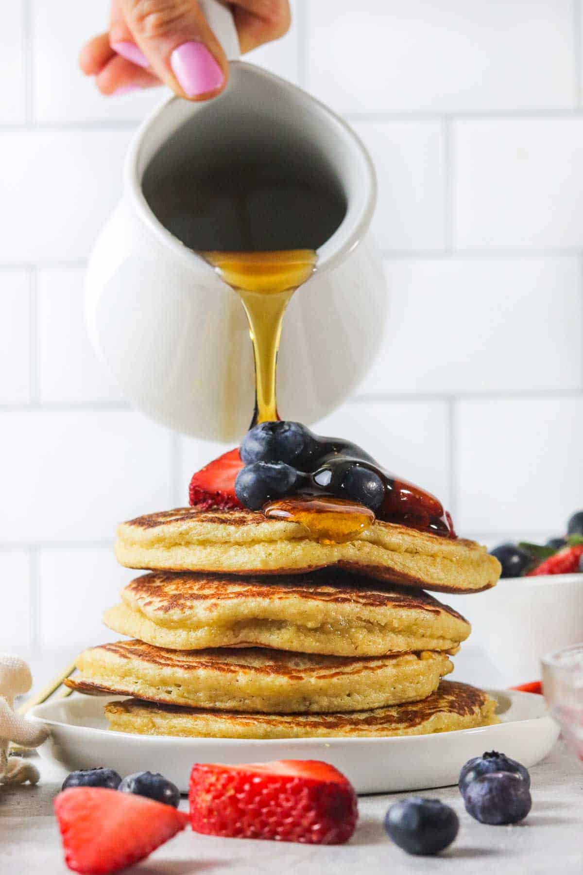pouring syrup on protein pancakes without protein powder or banana.