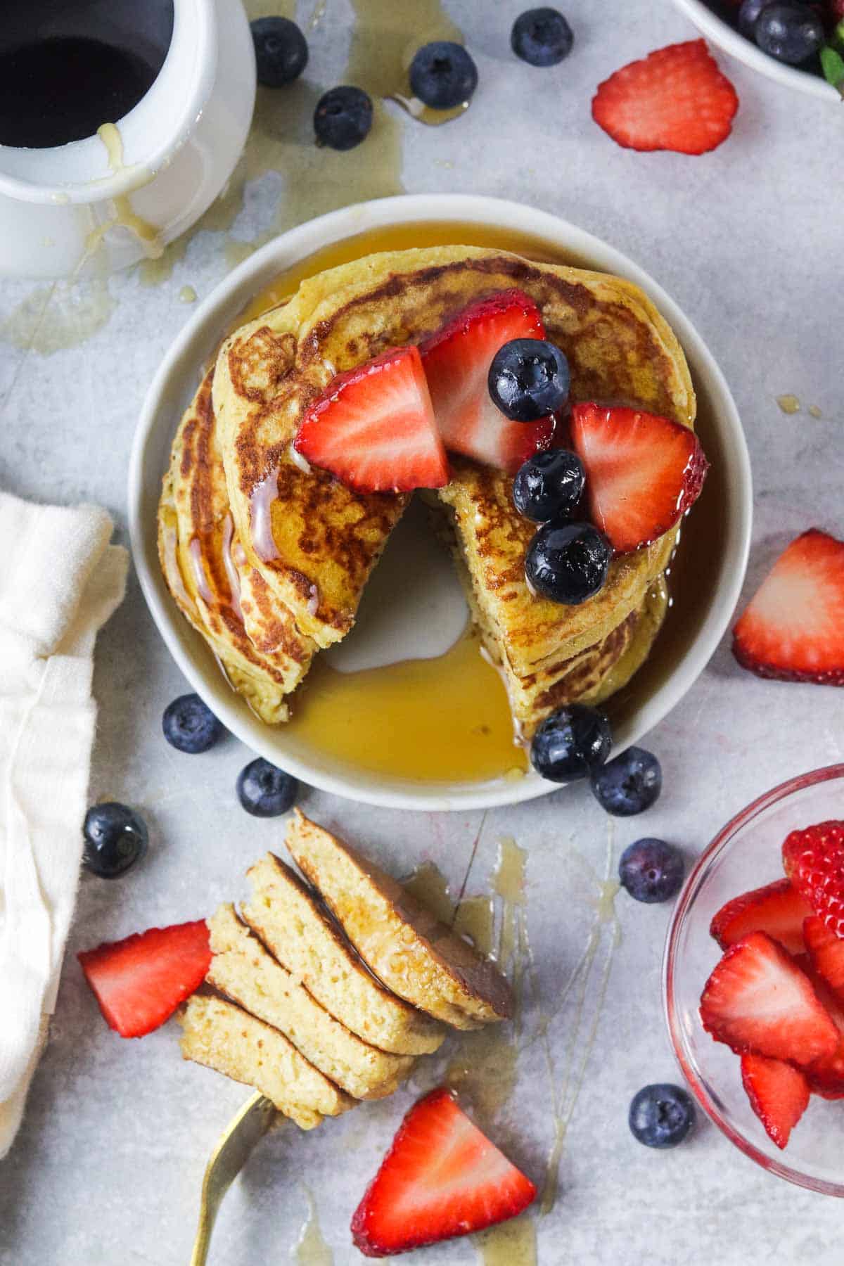 protein pancakes without banana covered in berries and maple syrup.
