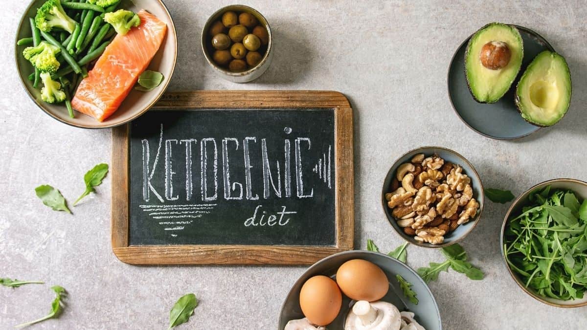 Ketogenic diet written on a chalkboard surrounded by higher fat foods.