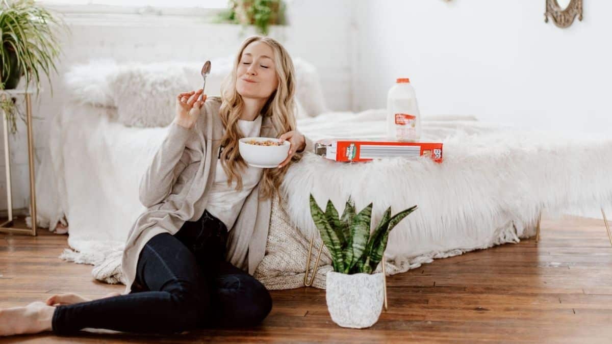 Colleen Christensen Intuitive Eating Dietitian Eating Cereal by a bed.