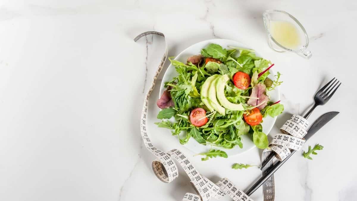 a salad and a tape measure on the counter.