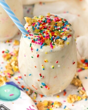 birthday cake protein shake on the counter with sprinkles and granola on top.