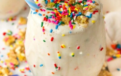 birthday cake protein shake on the counter with sprinkles and granola on top.