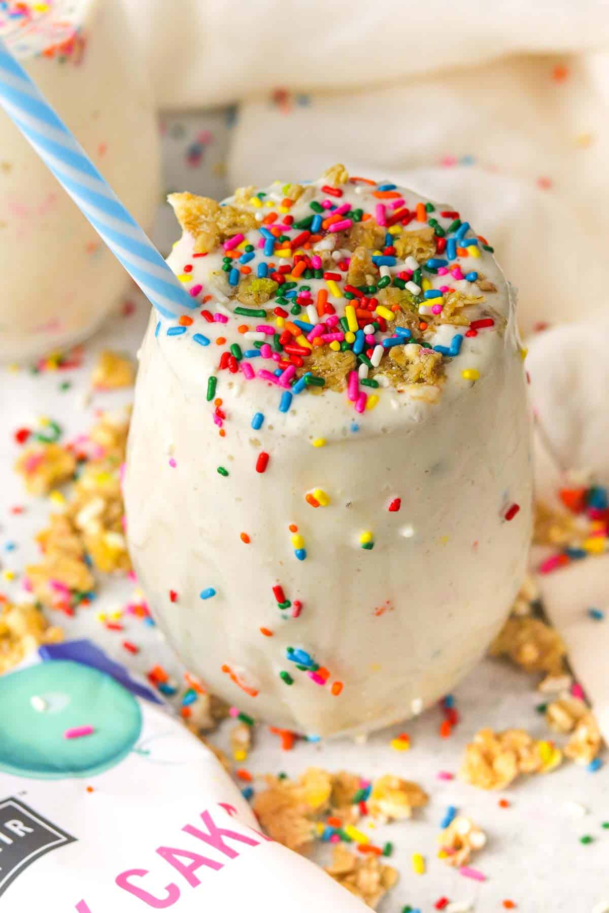 birthday cake protein shake on the counter with sprinkles and granola on top.