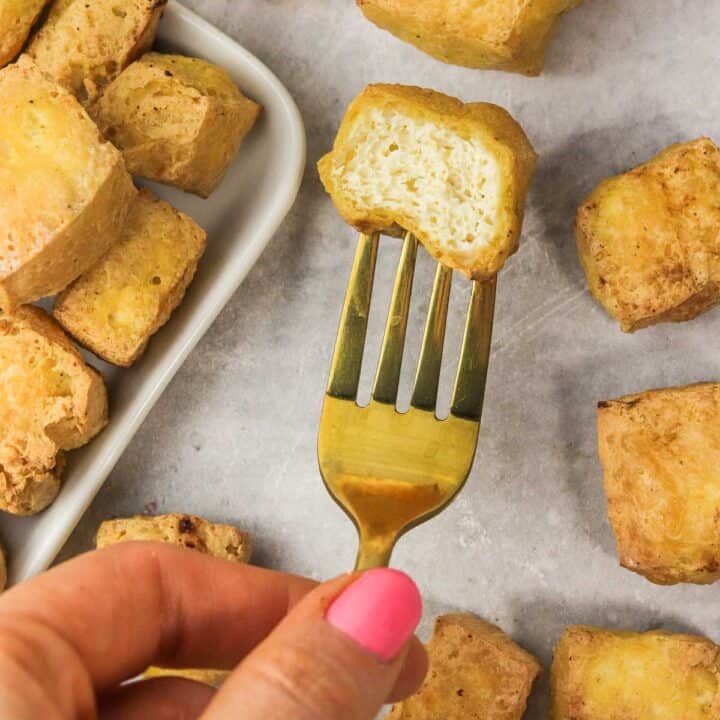 bitten air fryer tofu on a gold fork showing the inside.