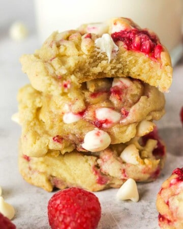 stacked white chocolate raspberry cookies with a bite out