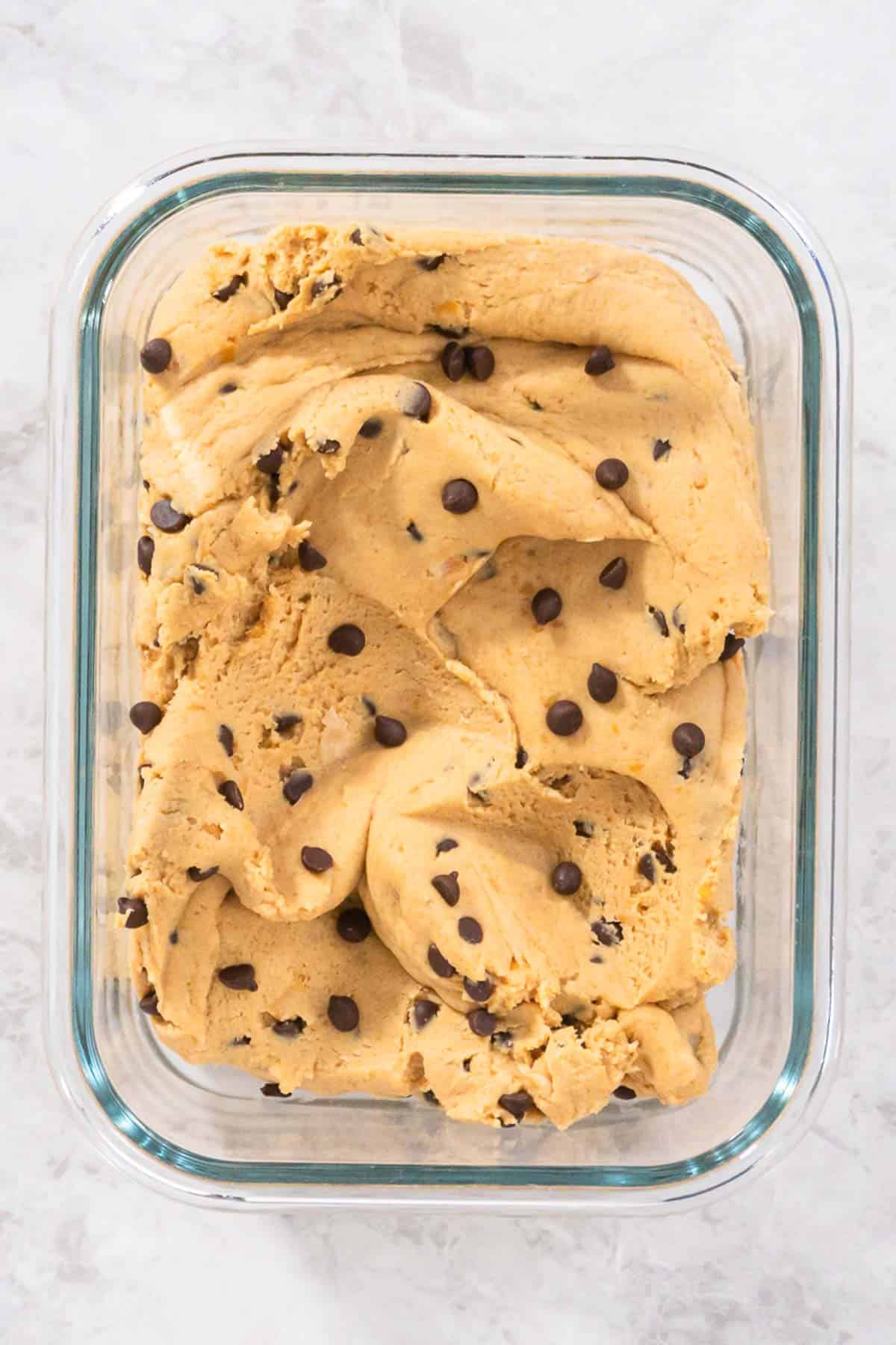 Chickpea cookie dough in a glass container on the counter.