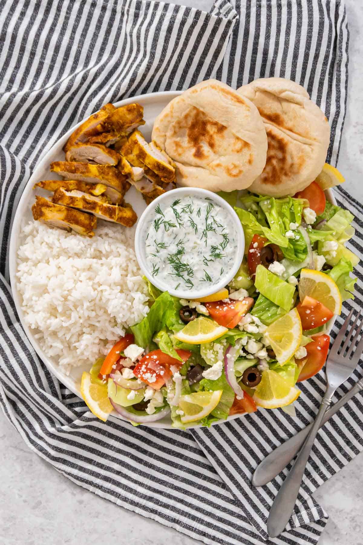 Up close chicken shawarma plate with a striped napkin.
