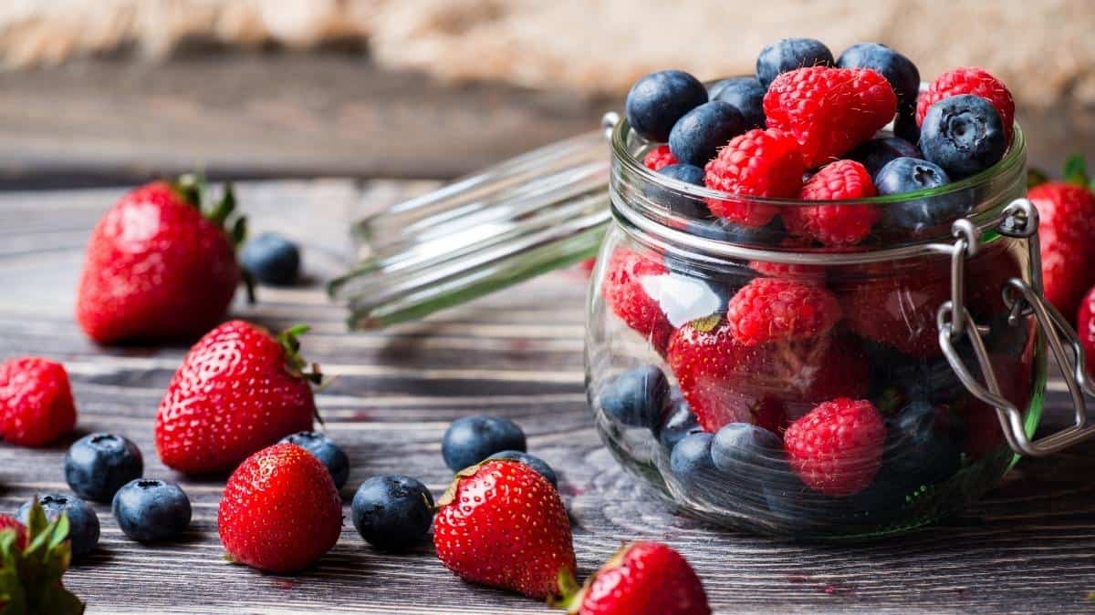 a beautiful display of colorful berries in a glass jar.